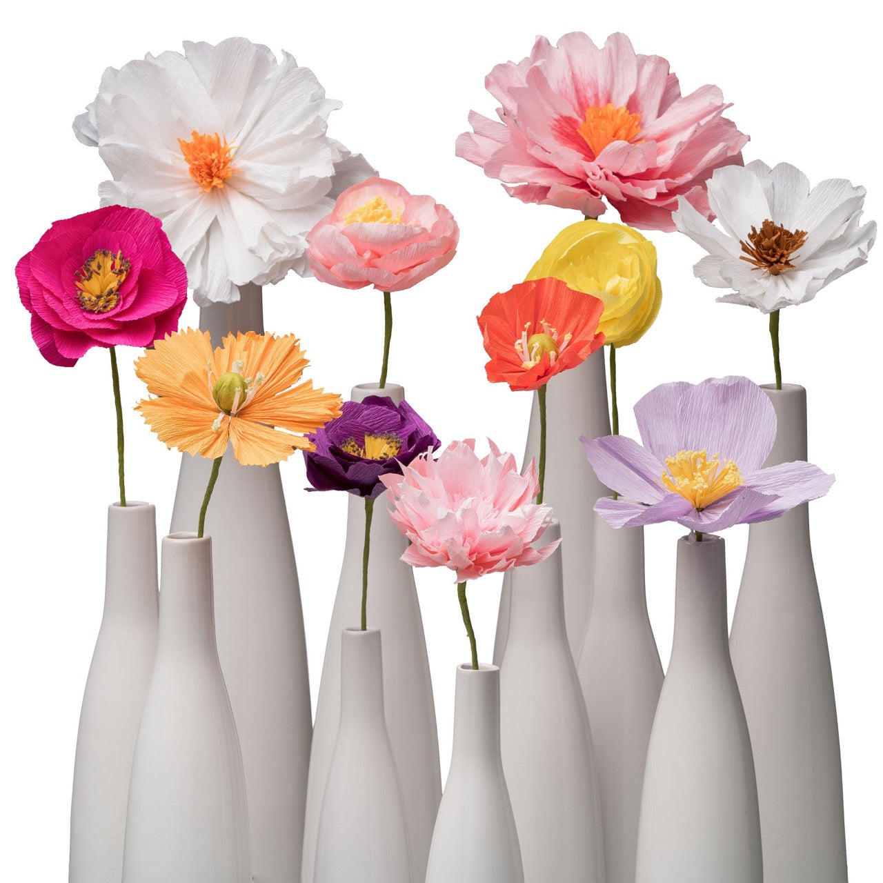 Farbenfrohes Arrangement aus handgefertigten Papierblumen in Weiß, Rosa, Gelb, Lila und Orange.
