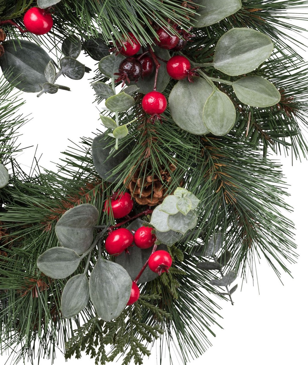 Detailaufnahme eines künstlichen Weihnachtskranzes mit roten Beeren, Eukalyptusblättern, Tannenzweigen und kleinen Zapfen – naturgetreue Weihnachtsdekoration