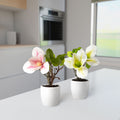 Zwei künstliche Magnolienpflanzen als stilvolle Fensterbank-Deko im Wohnzimmer