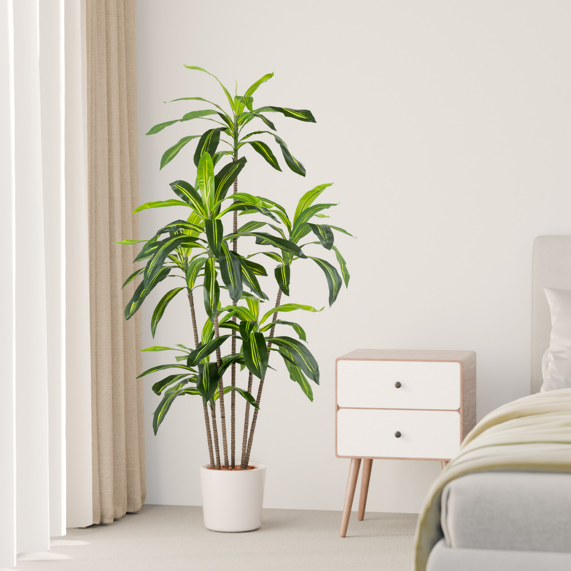Elegante künstliche Drachenbaum-Pflanze in einem weißen Übertopf stehend