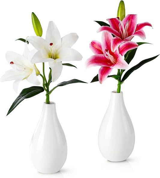 Zwei weiße Keramikvasen mit künstlichen orientalischen Lilien auf Holztisch
