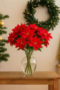 Künstlicher Weihnachtsstern als Strauß in Vase – realistische Poinsetta Stiele mit roten Blüten und grünen Blättern, perfekt für festliche Weihnachtsdekoration im Wohnzimmer.