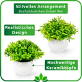 Keramiktöpfe mit künstlichen Pflanzen auf heller Holzablage
