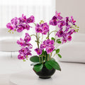 Künstliche Orchidee in Keramiktopf dekorativ auf Fensterbank platziert