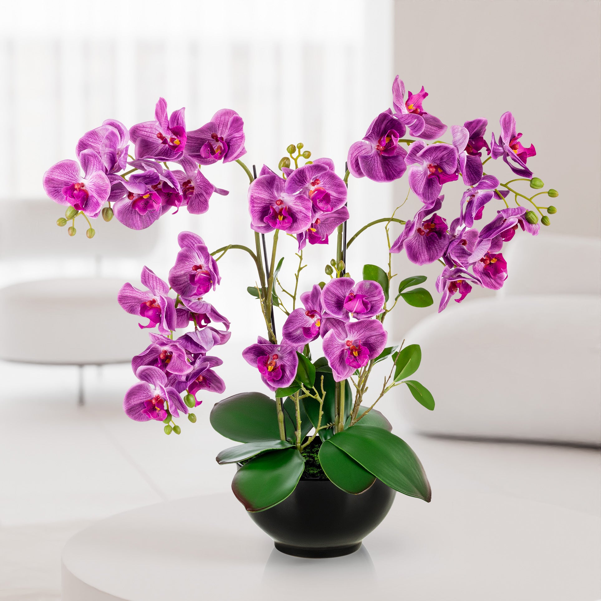 Künstliche Orchidee in Keramiktopf dekorativ auf Fensterbank platziert