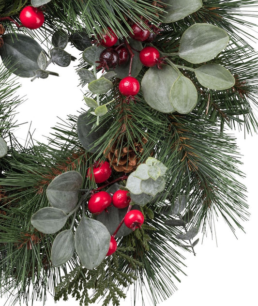 Detailaufnahme eines künstlichen Weihnachtskranzes mit roten Beeren, Eukalyptusblättern, Tannenzweigen und kleinen Zapfen – naturgetreue Weihnachtsdekoration